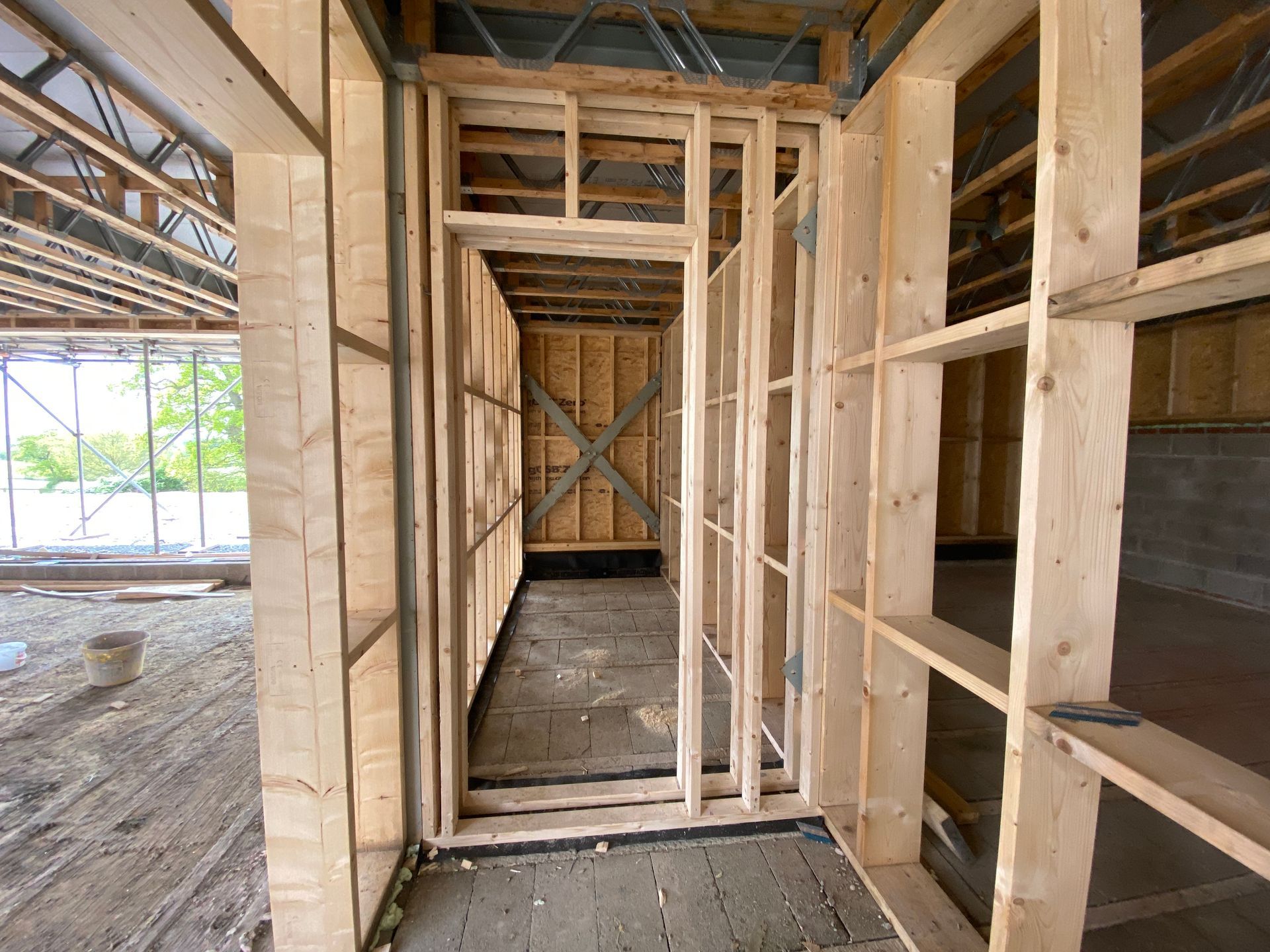 Interior wooden framing of a hallway under construction.
