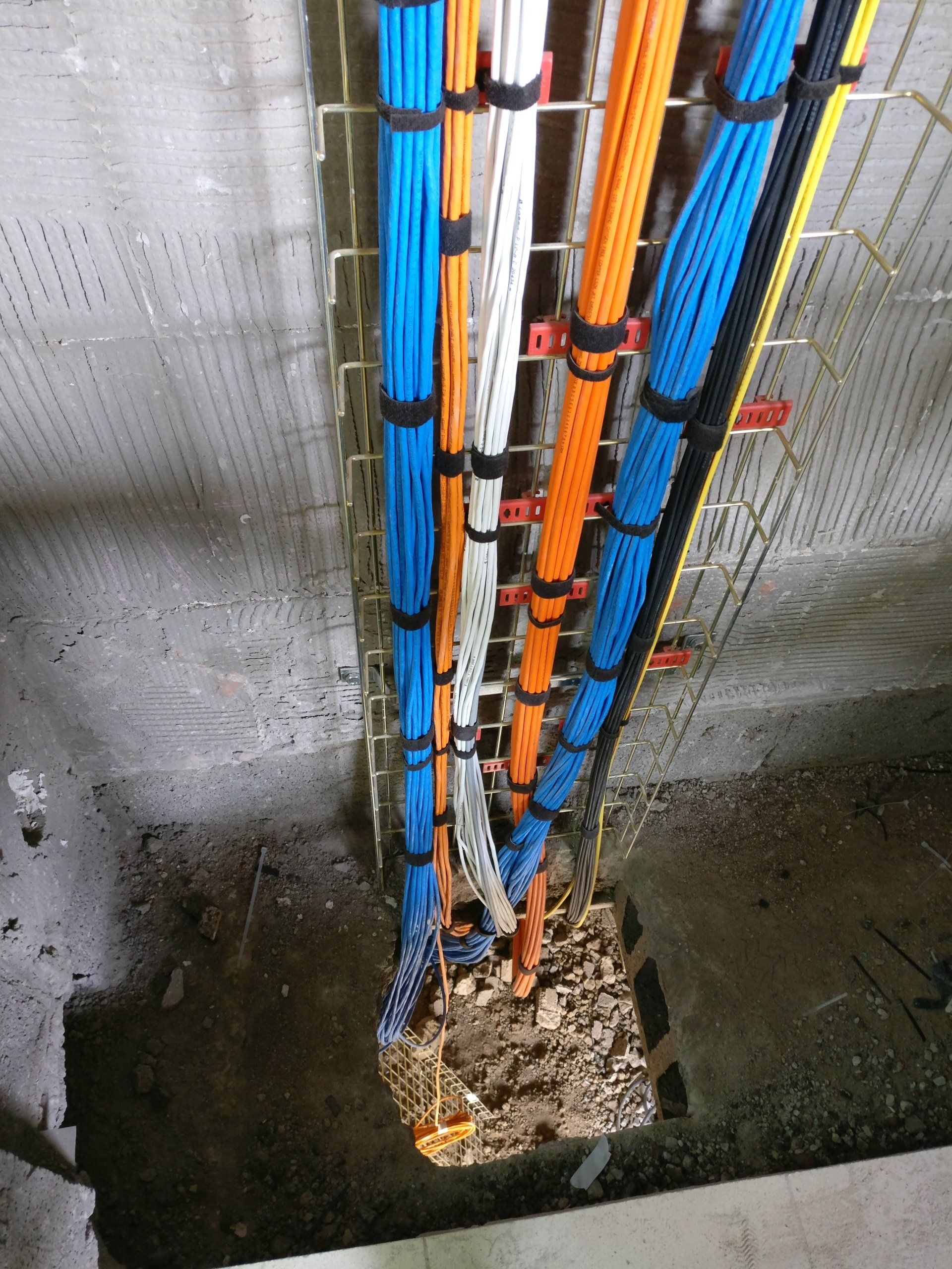 Photograph of pre-wire cables attached to basket tray in riser between floors