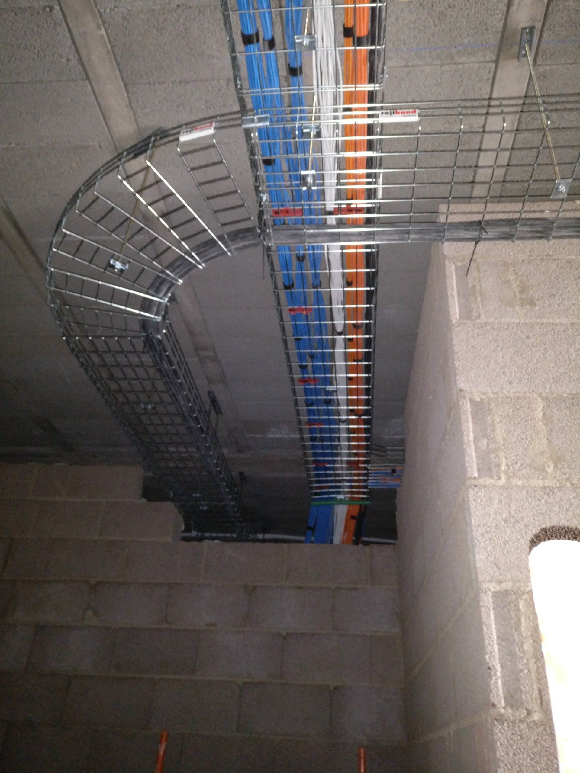Photograph of pre-wire cables attached to basket tray going into 'head-end'