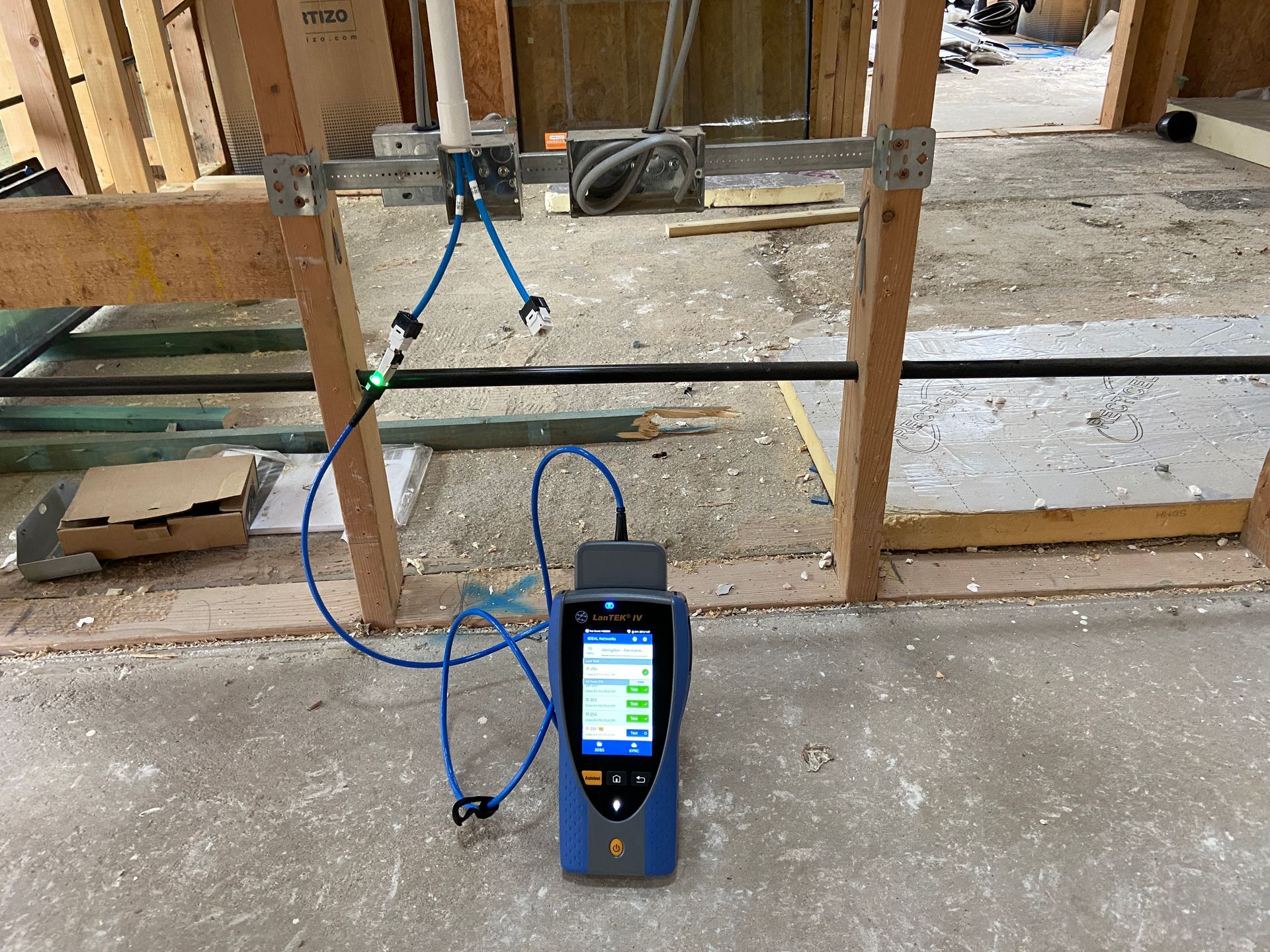 Photo of verification testing of CAT6A data cables prior to walls being closed up for plastering