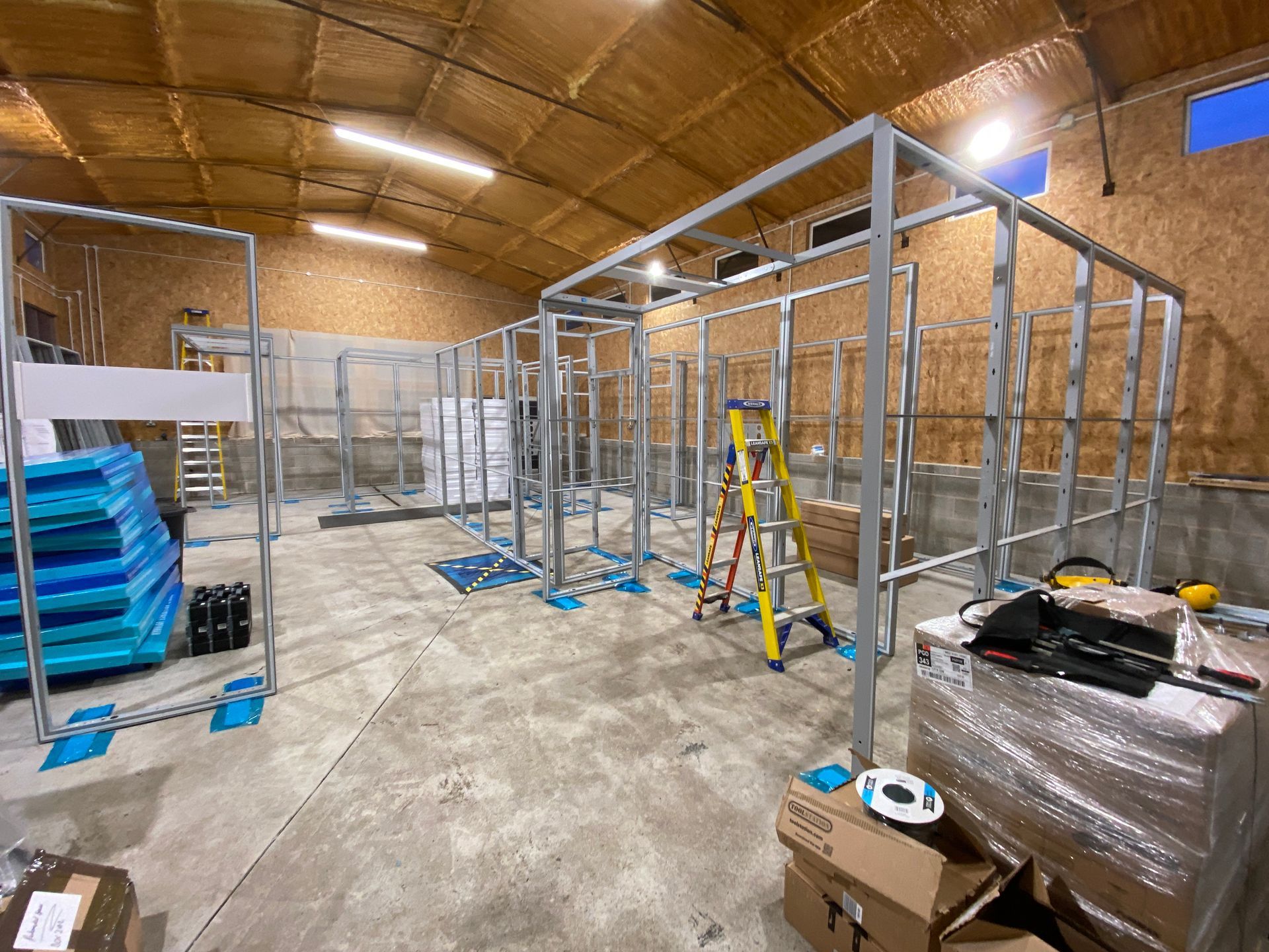 Photograph of prebuild of exhibition display system panels in workshop - several of the colleges