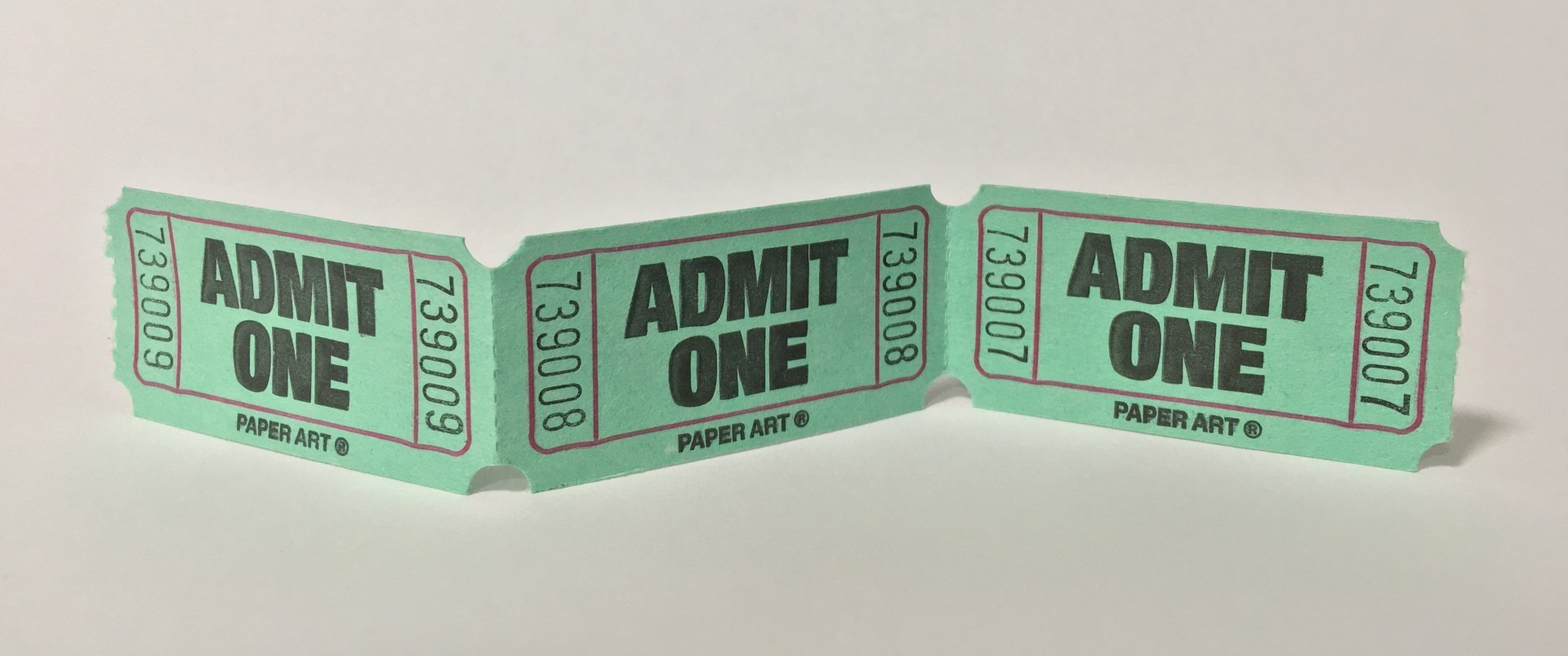 A photograph of 3 cinema paper entrance tickets that say Admit One on each of them