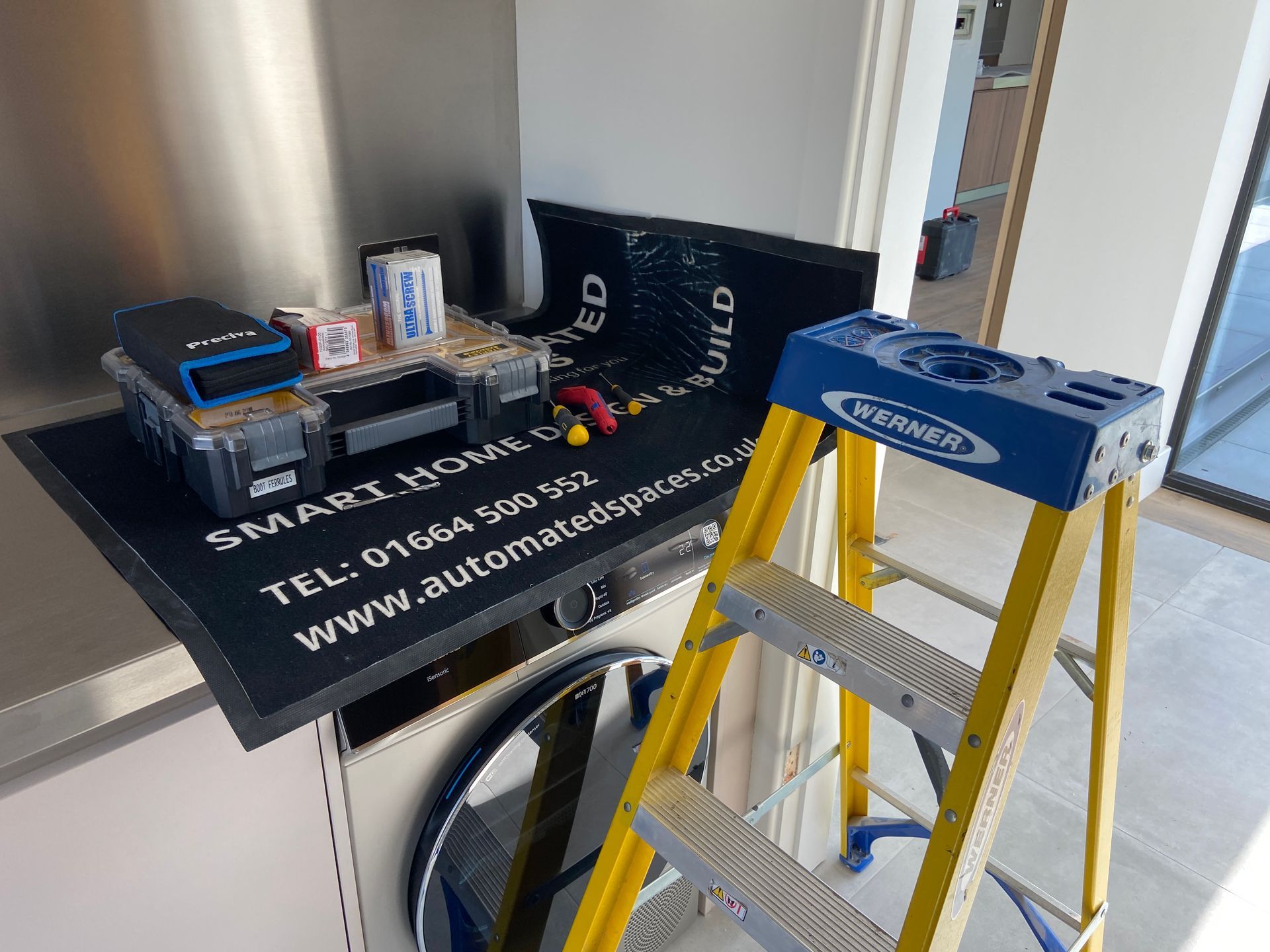 Photo of a mat with tools on top of it on top of a kitchen worktop with small step ladder next to it