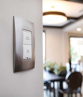 A photograph of a Control4 Keypad on a wall, with 2 buttons, 1 of which says Good Morning and the other says Good Night