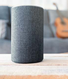 A photograph of an amazon alexa on a coffee table