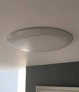 A photograph of a Control4 Pakedge in ceiling wireless access point