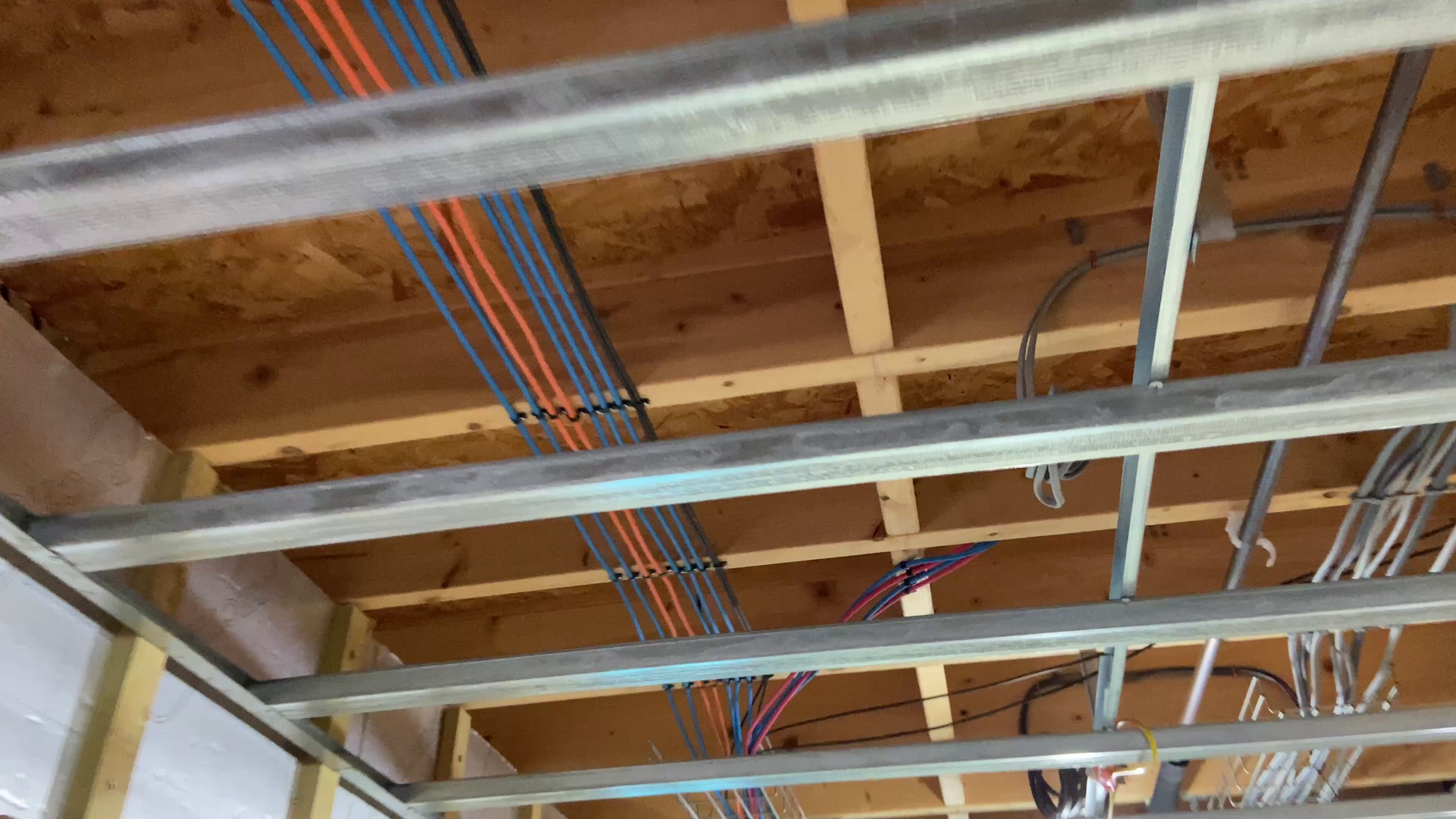 Photo of Metal fire rated cable clips attached to ceiling rafters