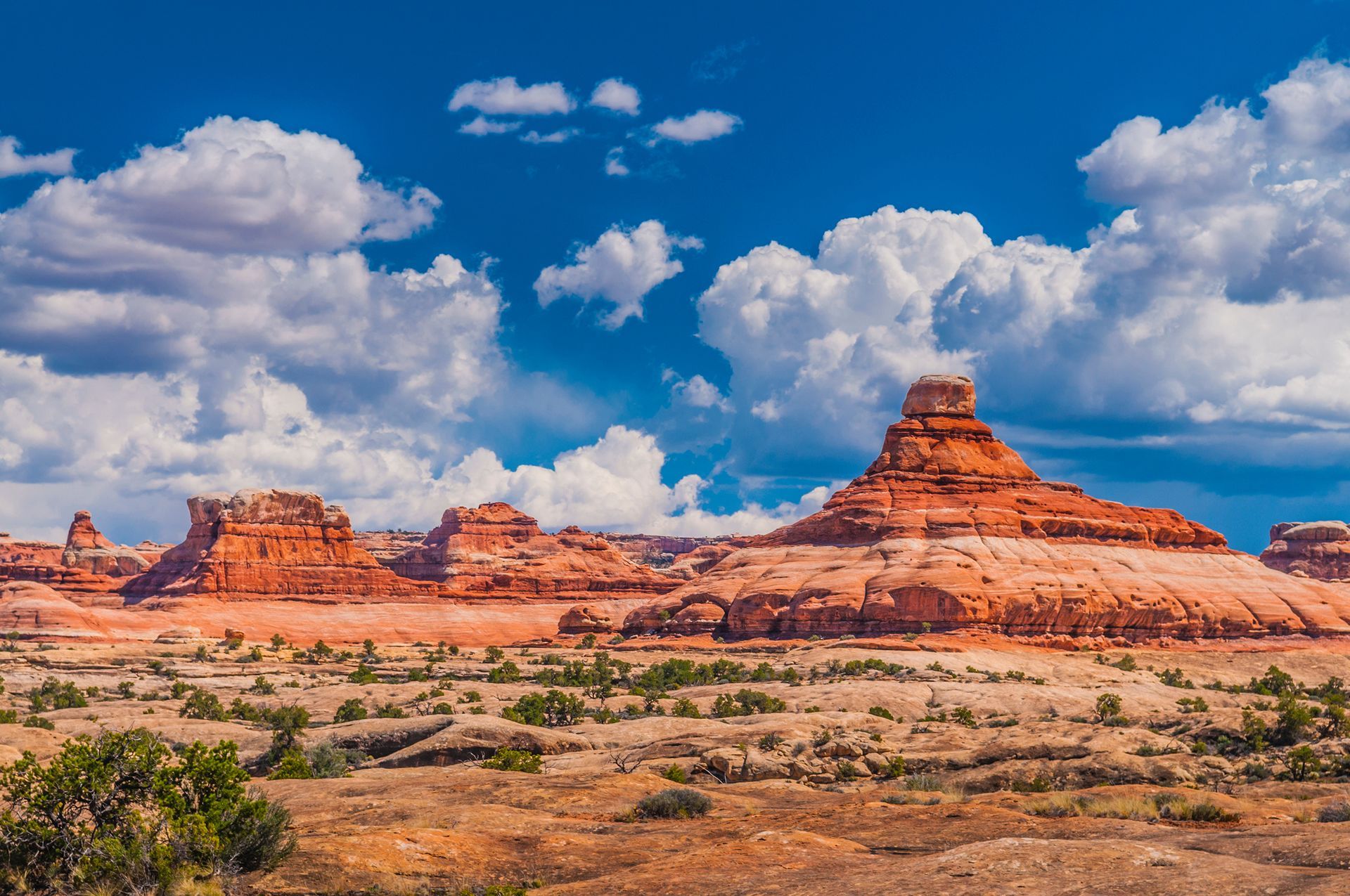 A desert landscape with mountains and clouds in the sky