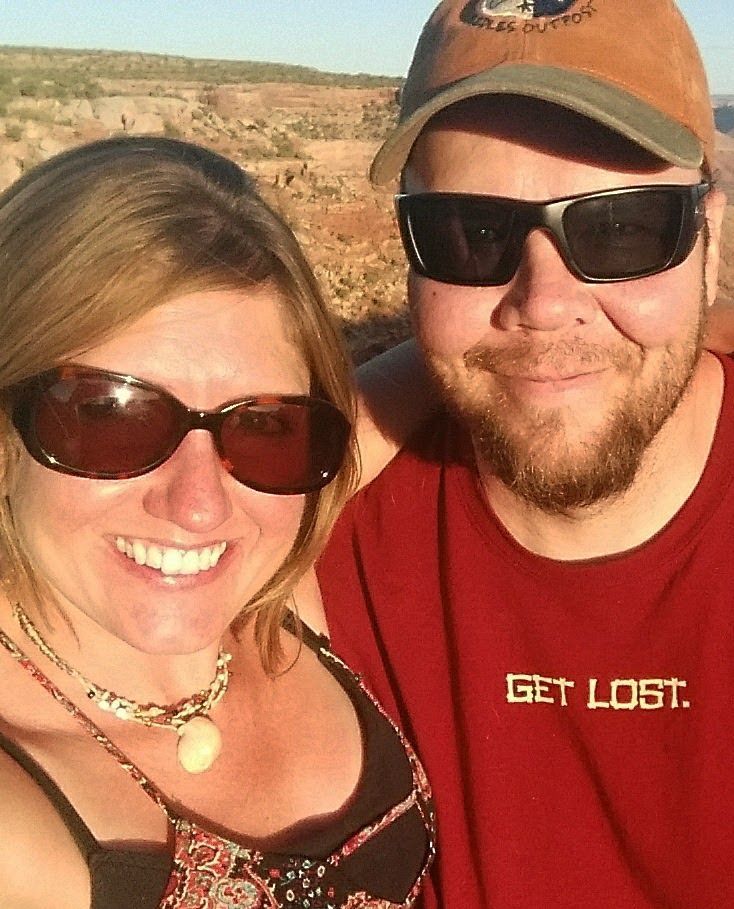 A man and a woman wearing sunglasses and a shirt that says get lost