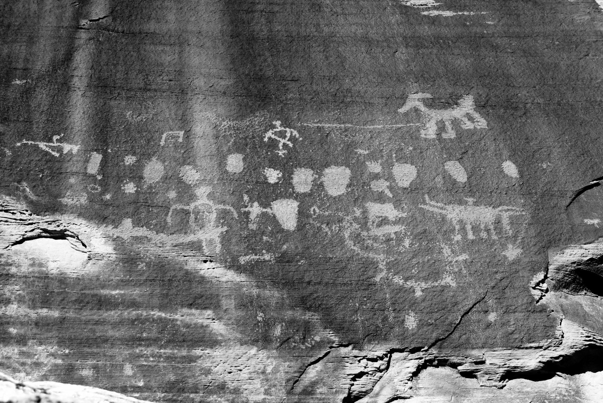 A black and white photo of a rock with petroglyphs on it.