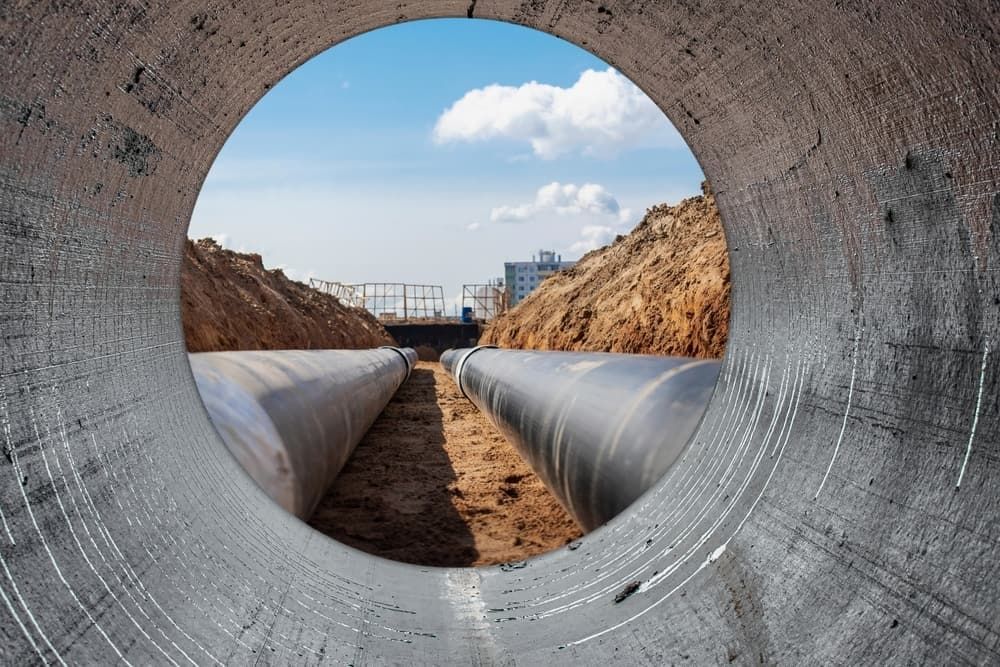 A View Of A Construction Site Through A Hole In A Pipe — DAVMAC Plumbing in Wauchope, NSW