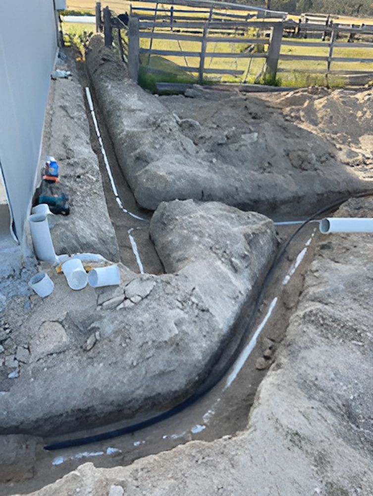 A Drainage System Is Being Installed On The Side Of A House — DAVMAC Plumbing in Wauchope, NSW
