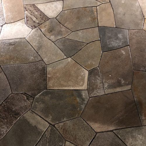 Irregularly shaped stone floor tiles in varying shades of brown and gray.