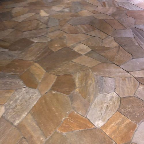Stone tile floor with irregular shapes in shades of brown and gray.