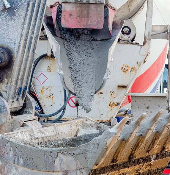 A concrete mixer is pouring concrete into a bucket.