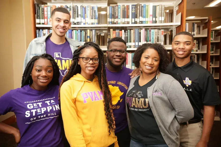 A group of people are posing for a picture in a library.