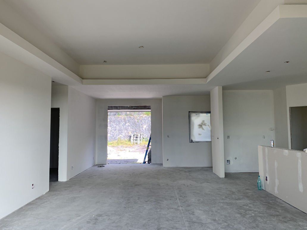 A large empty room with white walls and a concrete floor
