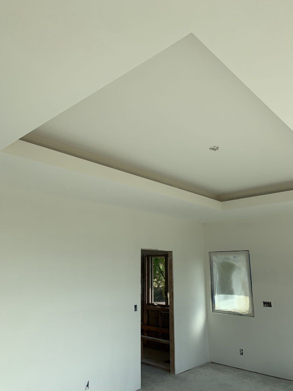 An empty room with white walls and a ceiling