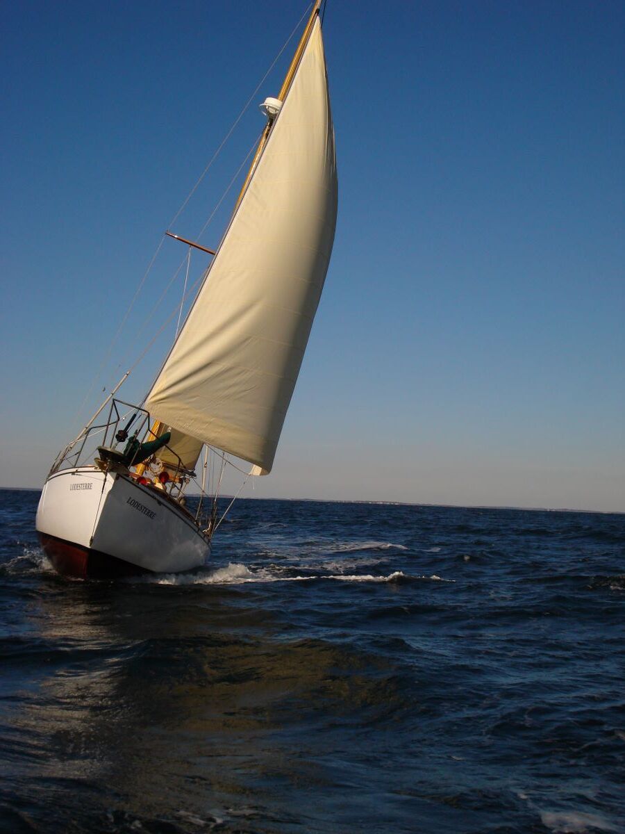A sailboat is floating on top of a large body of water