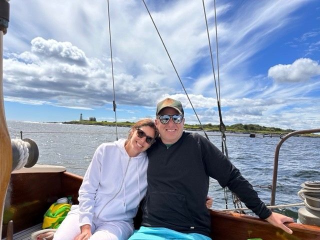A man and a woman are posing for a picture on a boat