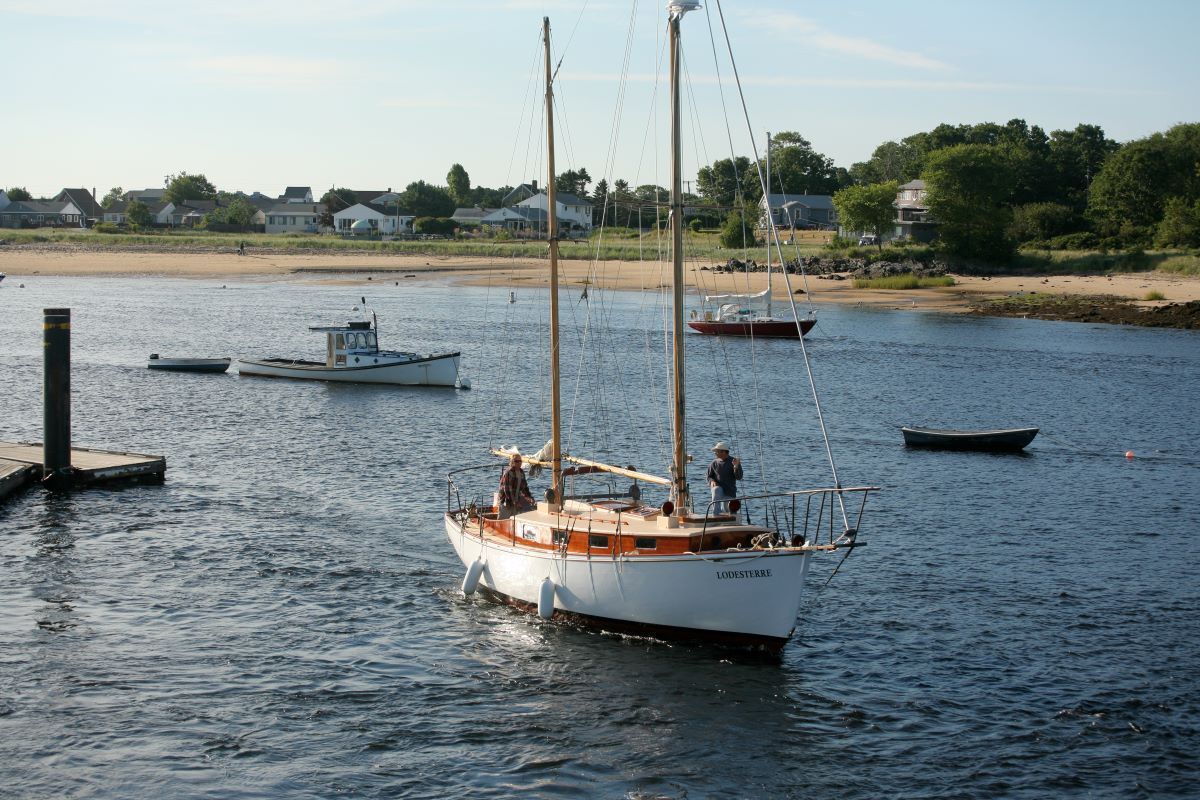A sailboat is docked in a harbor with other boats