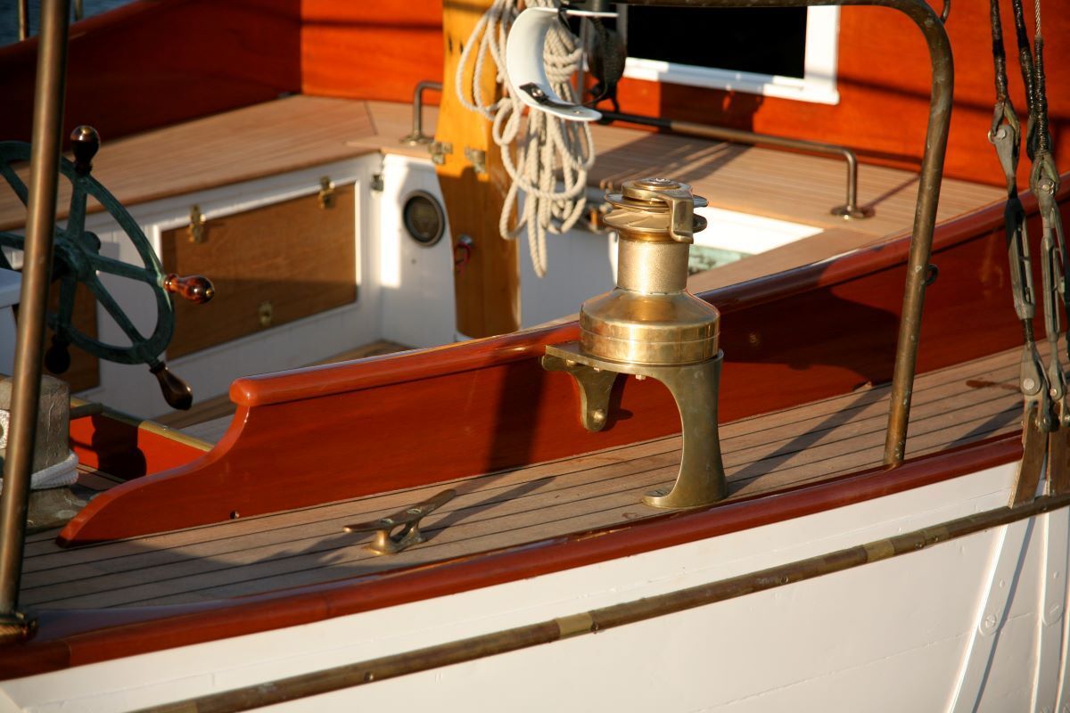 A boat with a steering wheel and a brass lantern on the deck
