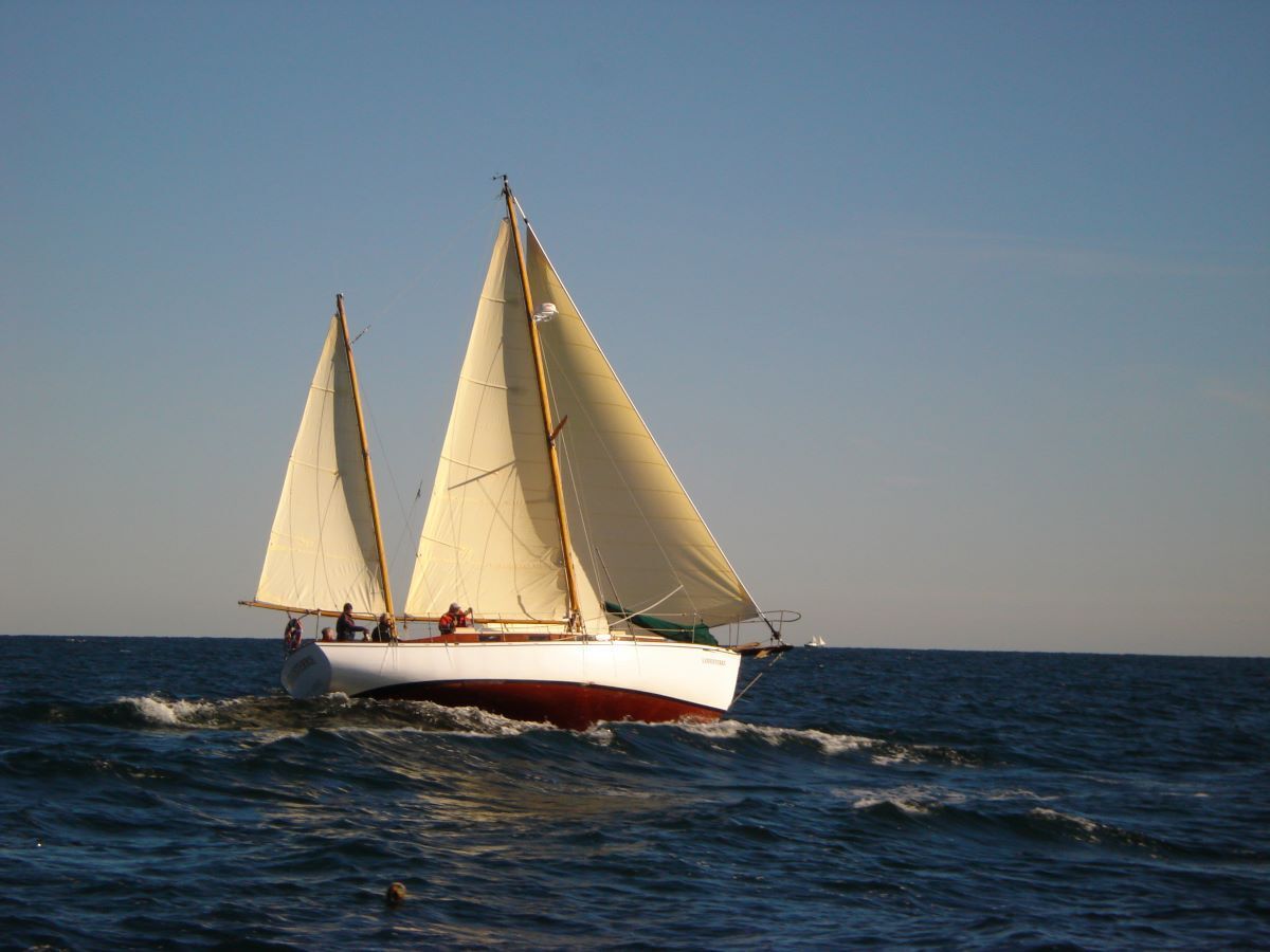 A sailboat is floating on top of a large body of water