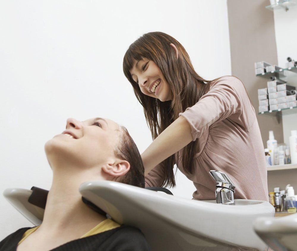 Client having hair washed by hairdresser