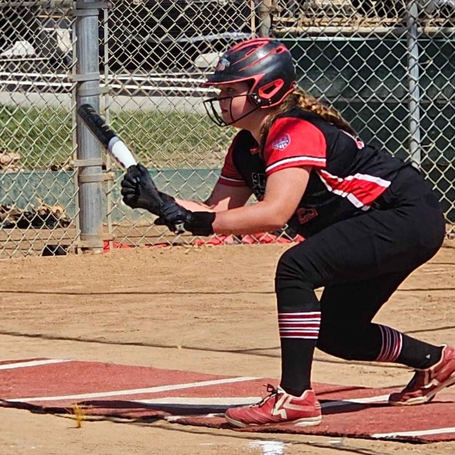 Baseball player sliding into base as another player attempts to catch the ball.