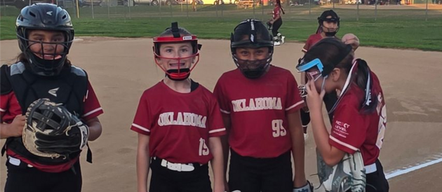 Baseball player sliding into home plate, catcher in front. Blue and gold uniforms, action shot.