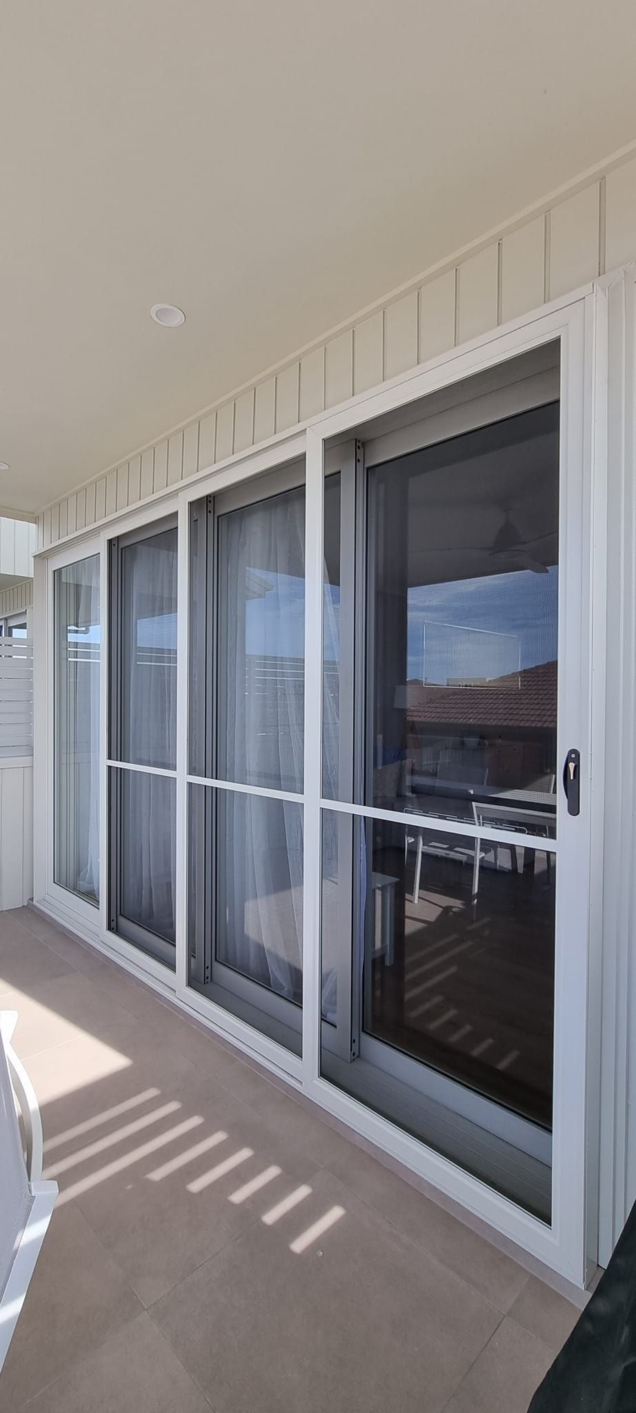 A balcony with a lot of windows and sliding glass doors.