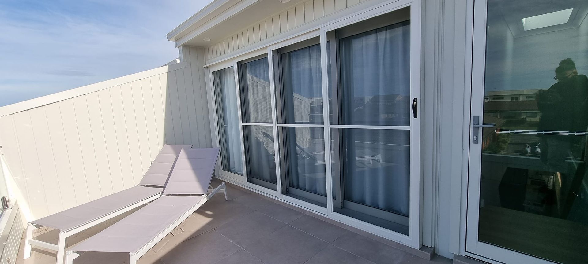 A balcony with a lot of windows and chairs