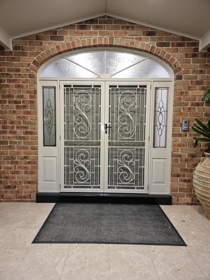 A brick building with a white door and a black mat in front of it.