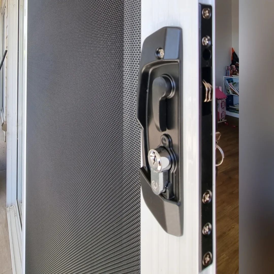 A close up of a sliding glass door with a lock on it.