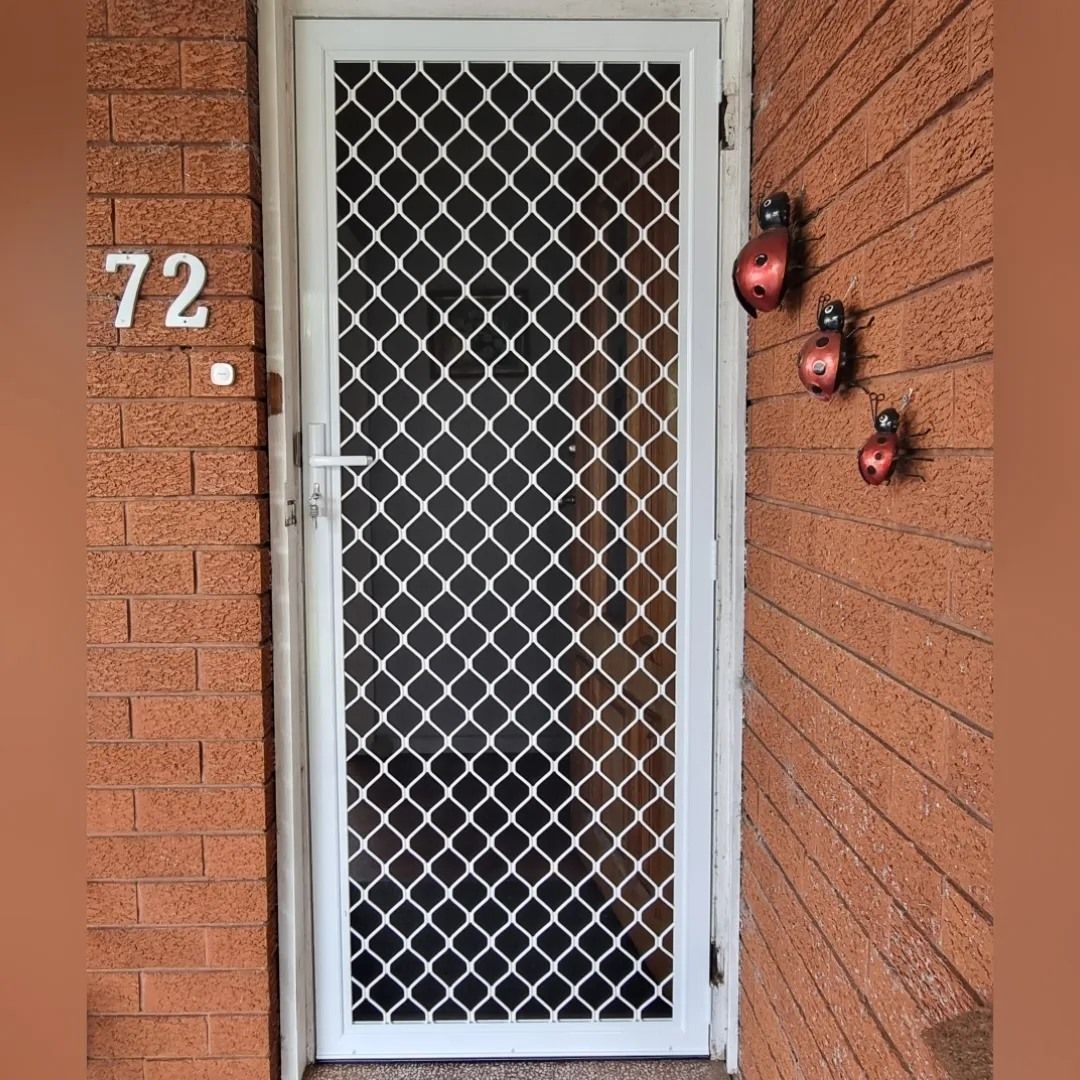 A white door is sitting on a brick wall next to a brick wall.