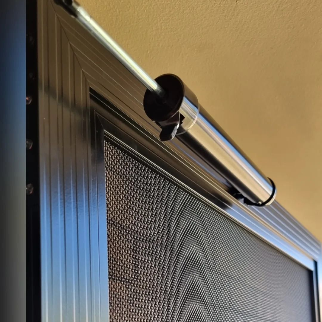 A close up of a screen door with a light attached to it