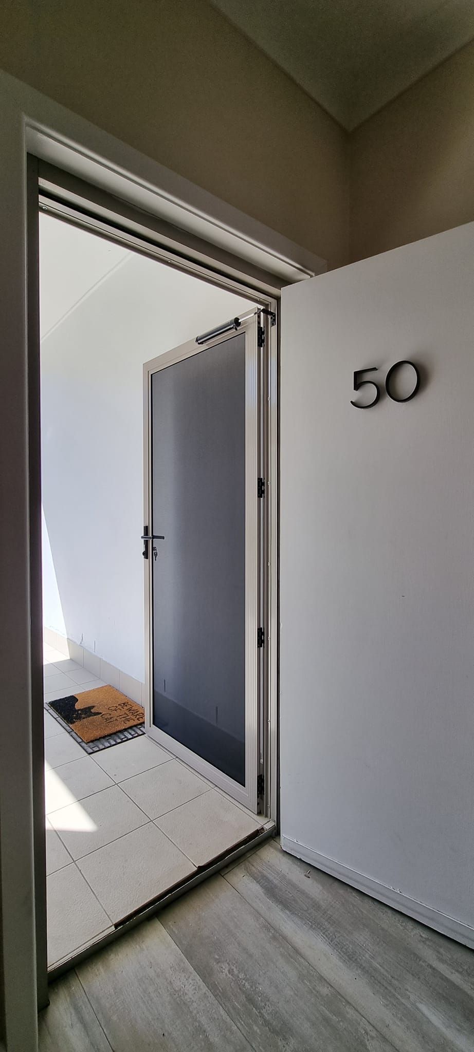 A door with the number 50 on it is open to a hallway.