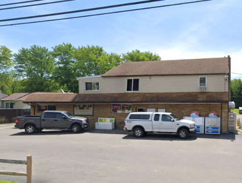 Two trucks are parked in front of a building.
