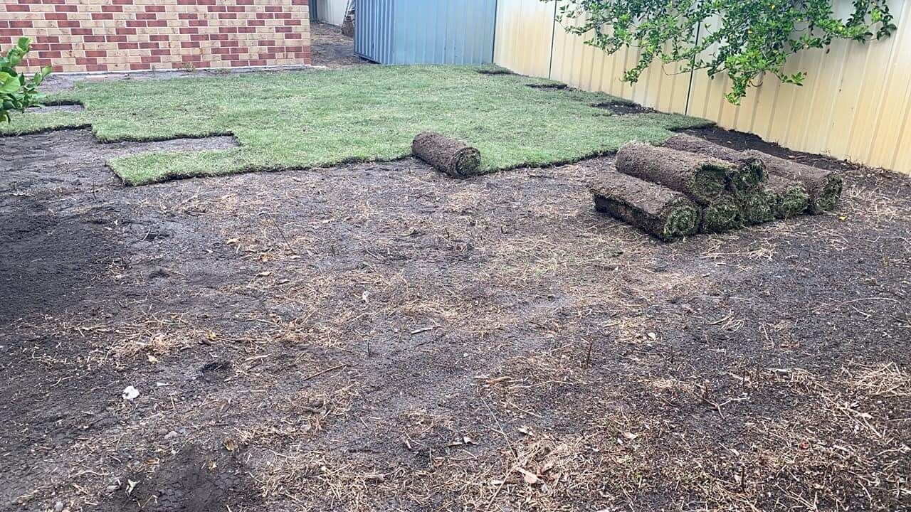 Backyard With Soil Prepared for Sod; Rolls and Sheets of Grass Are Present — Coastal Slashing & Mowing Services In Wingham, NSW