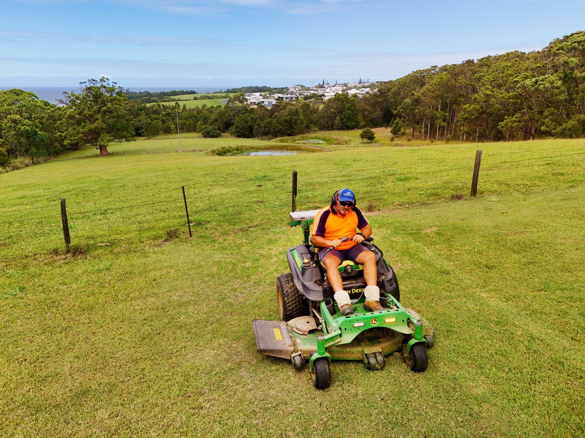 A Person Wearing a High-visibility Orange Shirt and Protective Earmuffs — Coastal Slashing & Mowing Services In Wingham, NSW