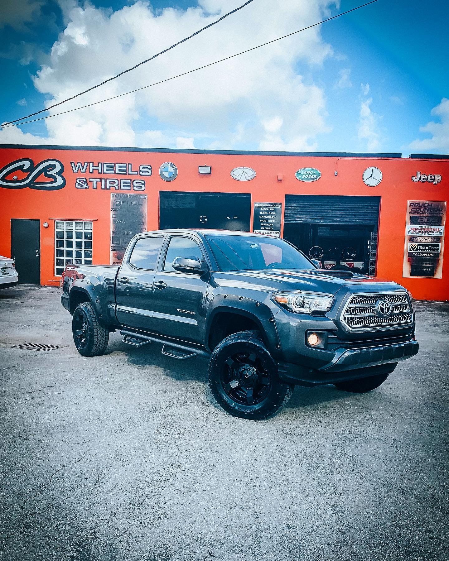 A toyota tacoma truck is parked in front of a tire shop. | CB Wheels & Tires, 4x4, Suspension, Center