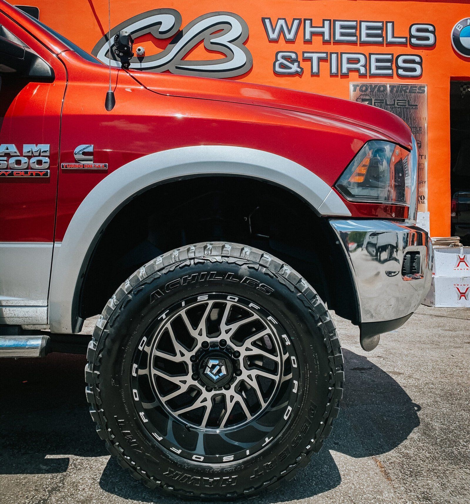 A red truck is parked in front of a cb wheels and tires sign | CB Wheels & Tires, 4x4, Suspension, Center