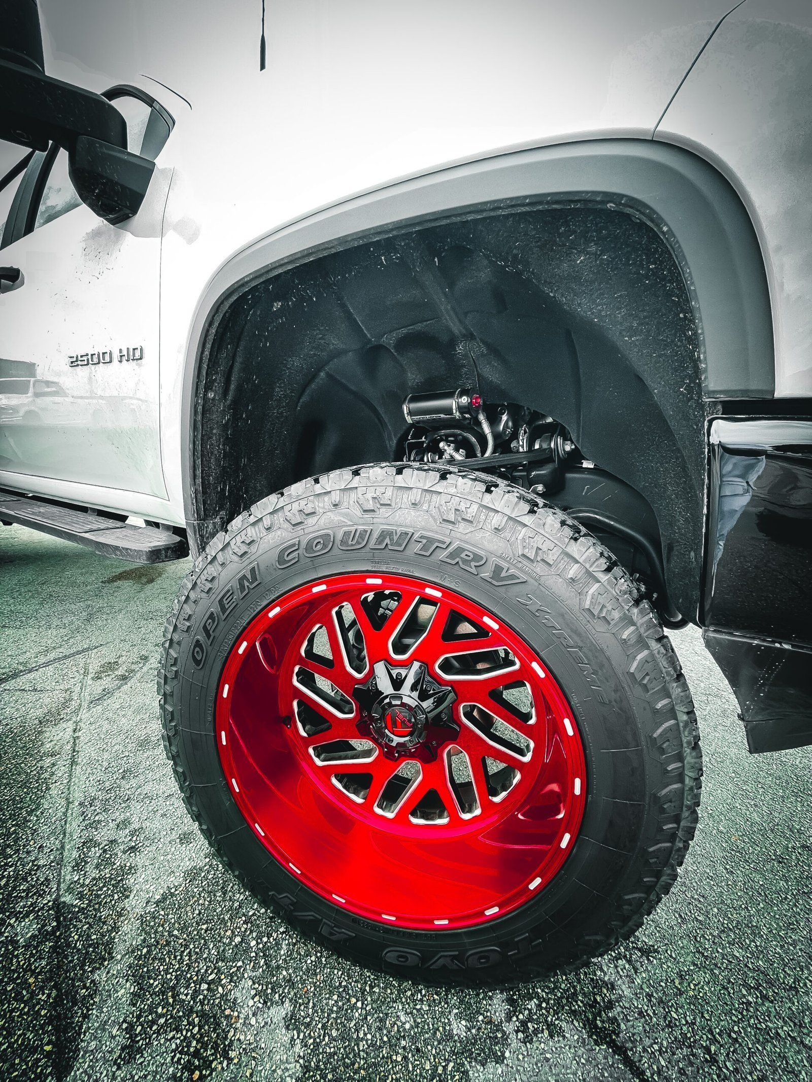 A white truck with red wheels and tires is parked on the grass. | CB Wheels & Tires, 4x4, Suspension, Center