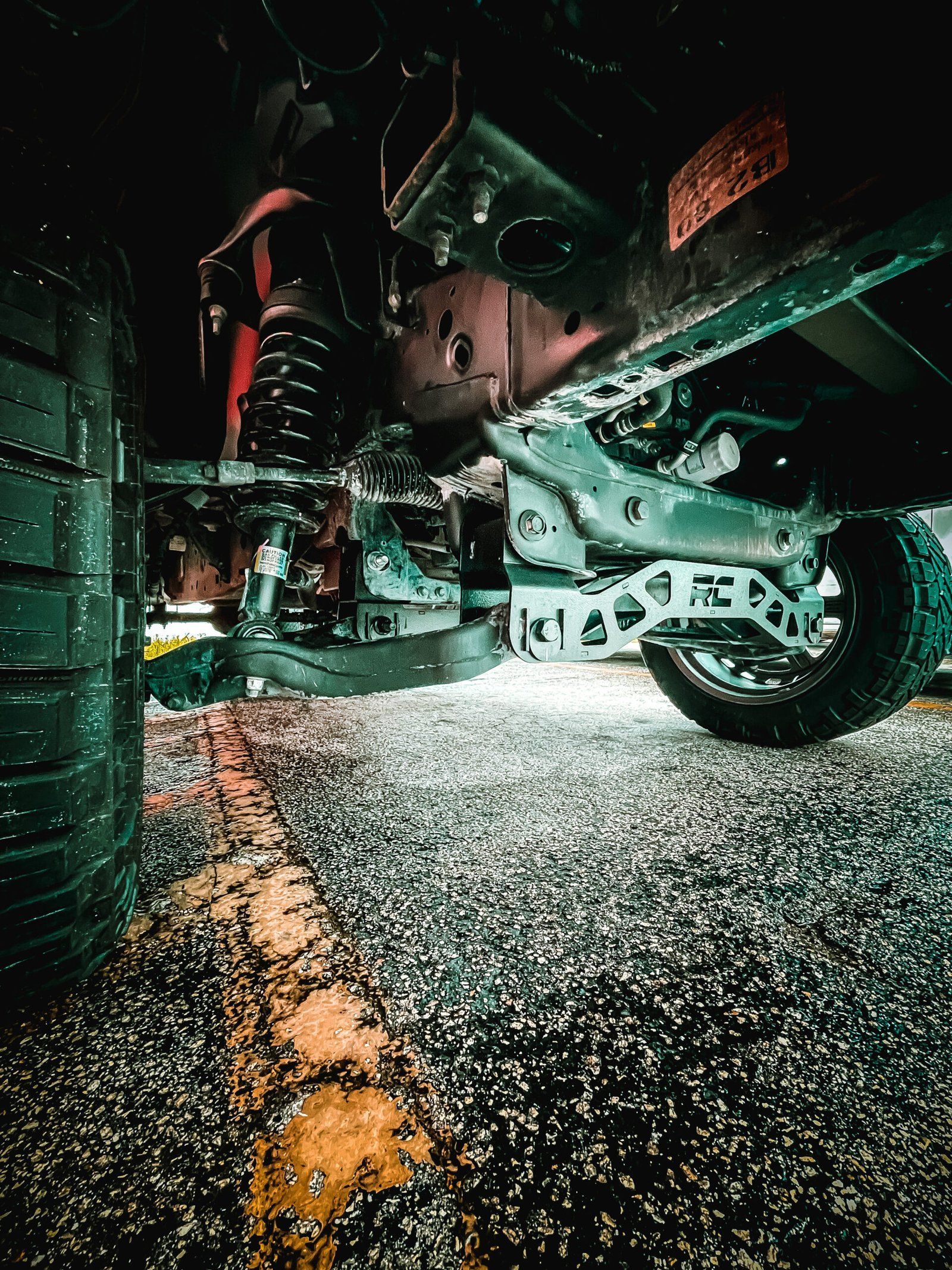 A close up of the underside of a car parked in a parking lot. | CB Wheels & Tires, 4x4, Suspension, Center