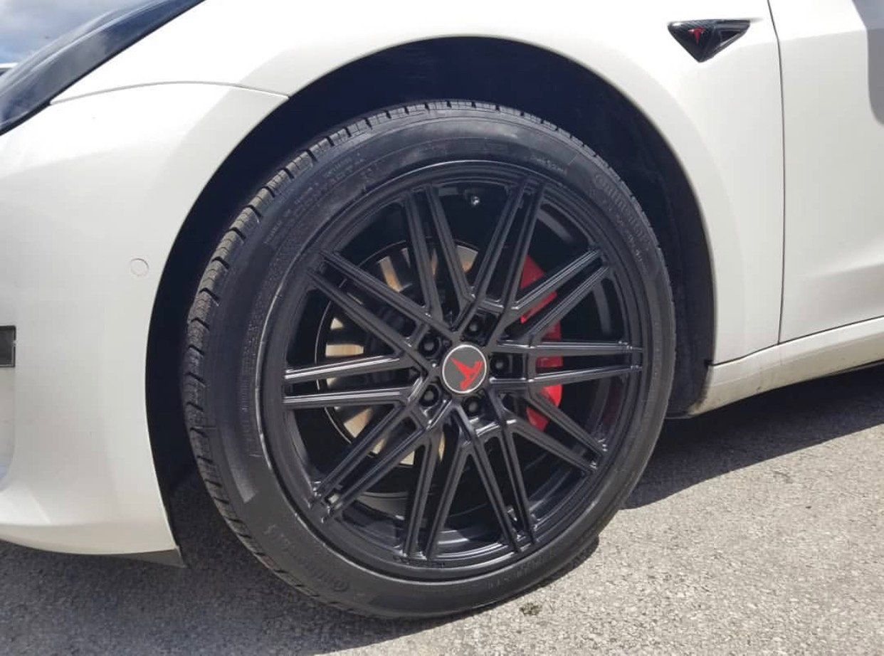 A white tesla model 3 with black wheels and red brake calipers is parked on the side of the road. | CB Wheels & Tires, 4x4, Suspension, Center