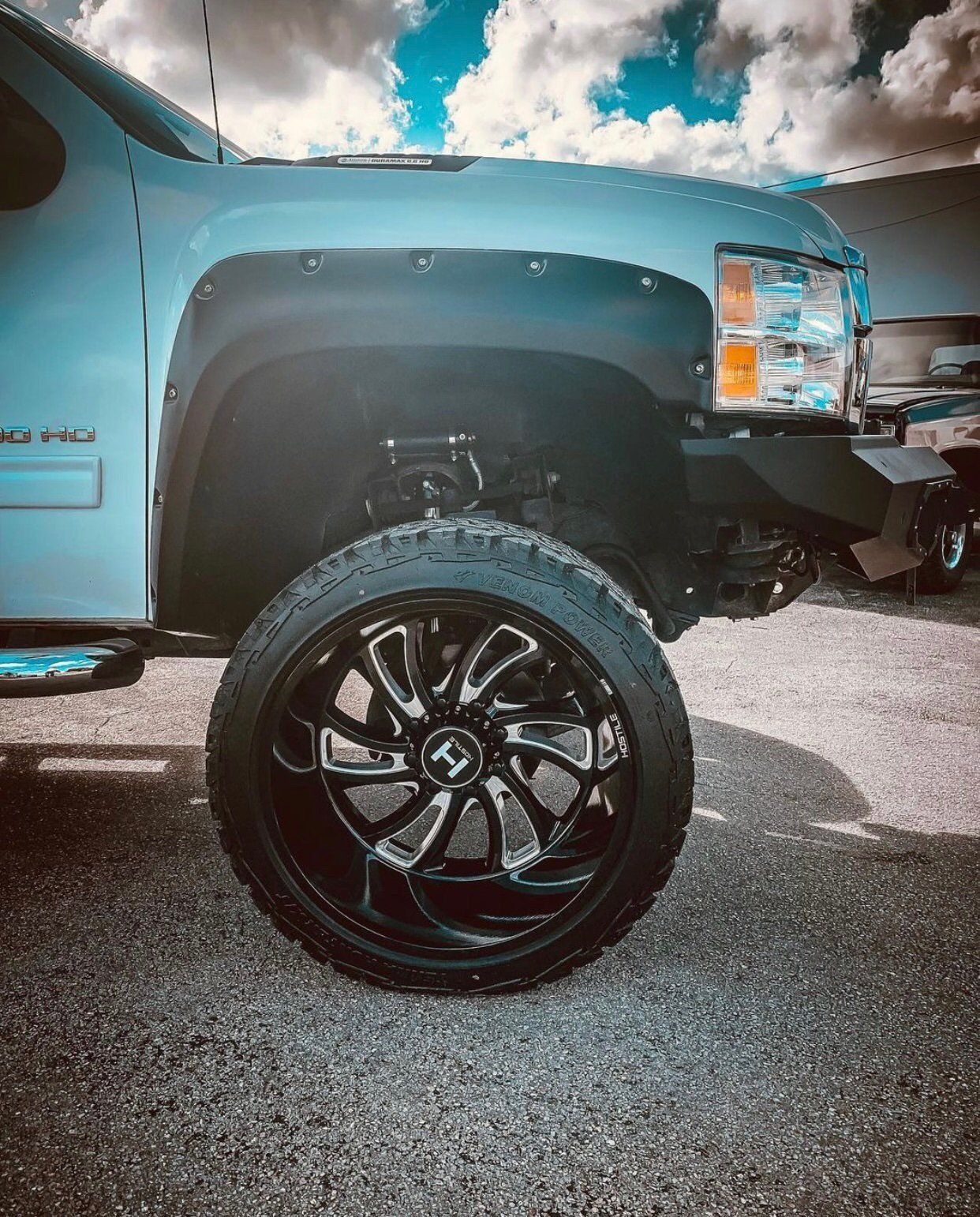 A white truck with black wheels and tires is parked in a parking lot. | CB Wheels & Tires, 4x4, Suspension, Center