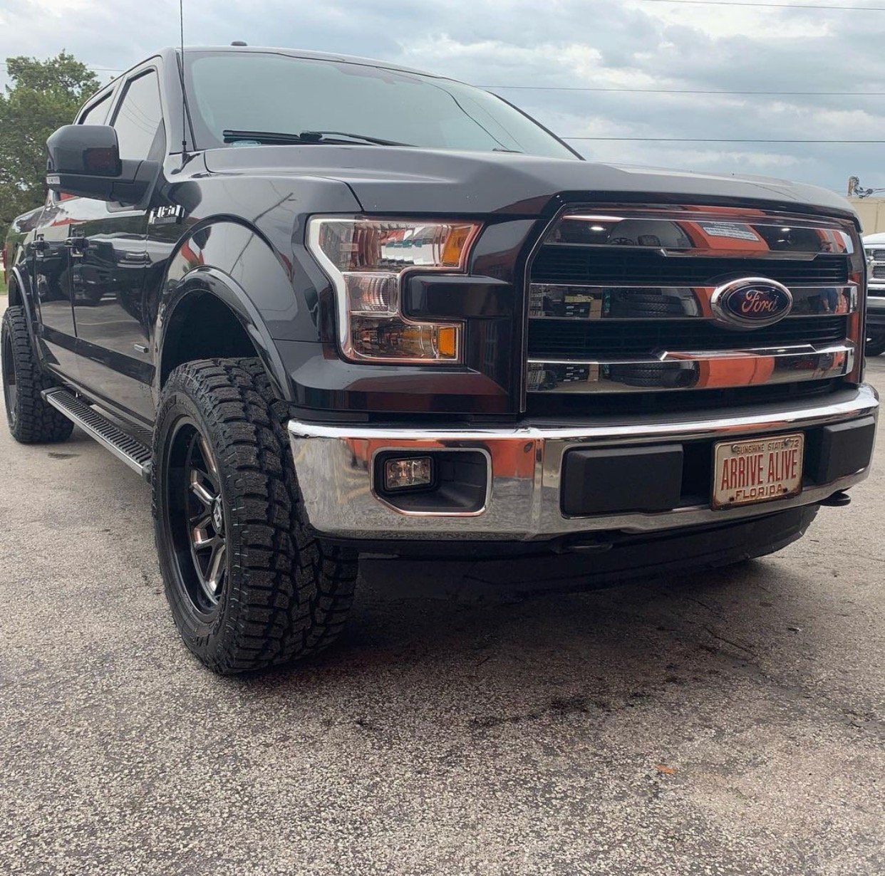 A black ford truck is parked in a parking lot | CB Wheels & Tires, 4x4, Suspension, Center