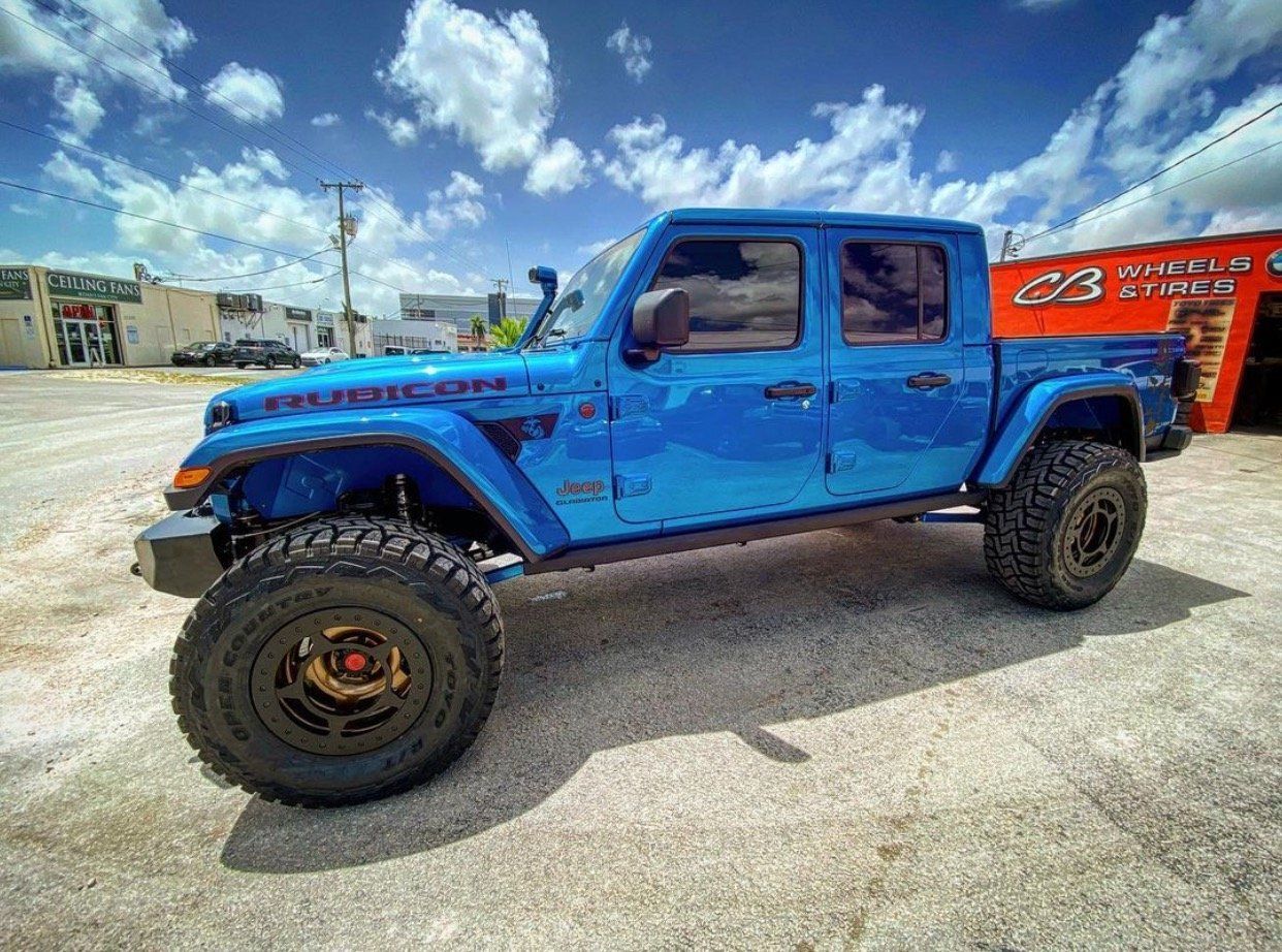 A blue jeep gladiator is parked in a parking lot. | CB Wheels & Tires, 4x4, Suspension, Center