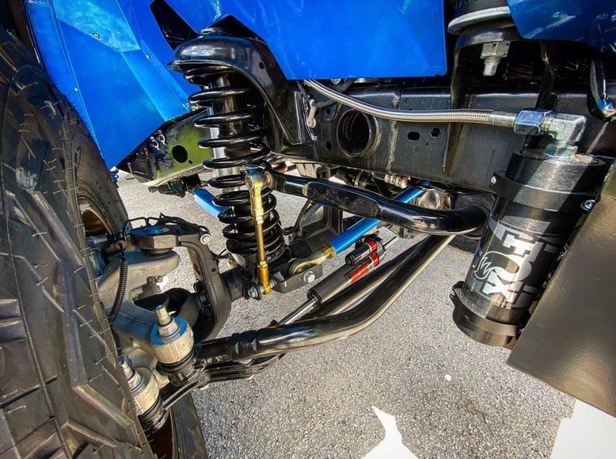 A close up of the front suspension of a blue truck. | CB Wheels & Tires, 4x4, Suspension, Center