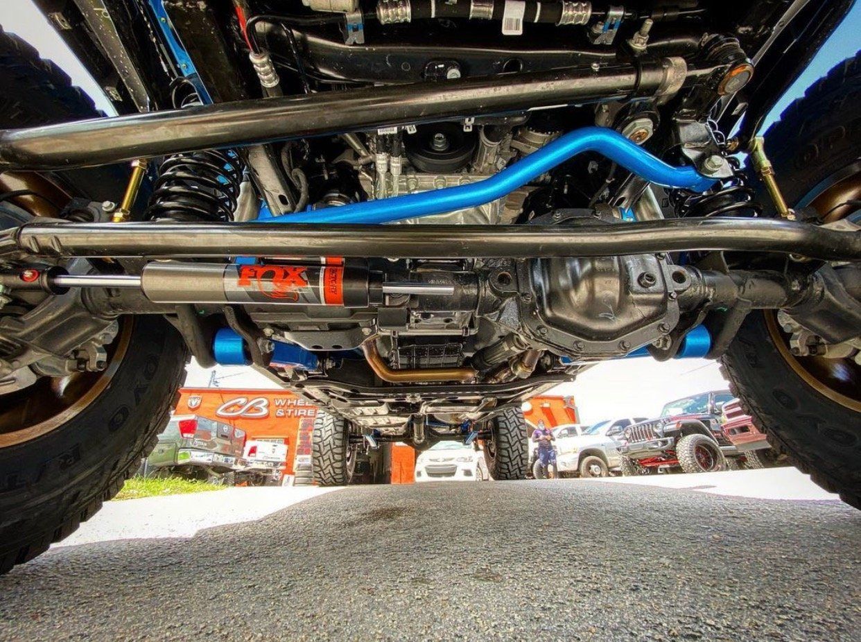 A close up of the underside of a jeep parked on the side of the road. | CB Wheels & Tires, 4x4, Suspension, Center